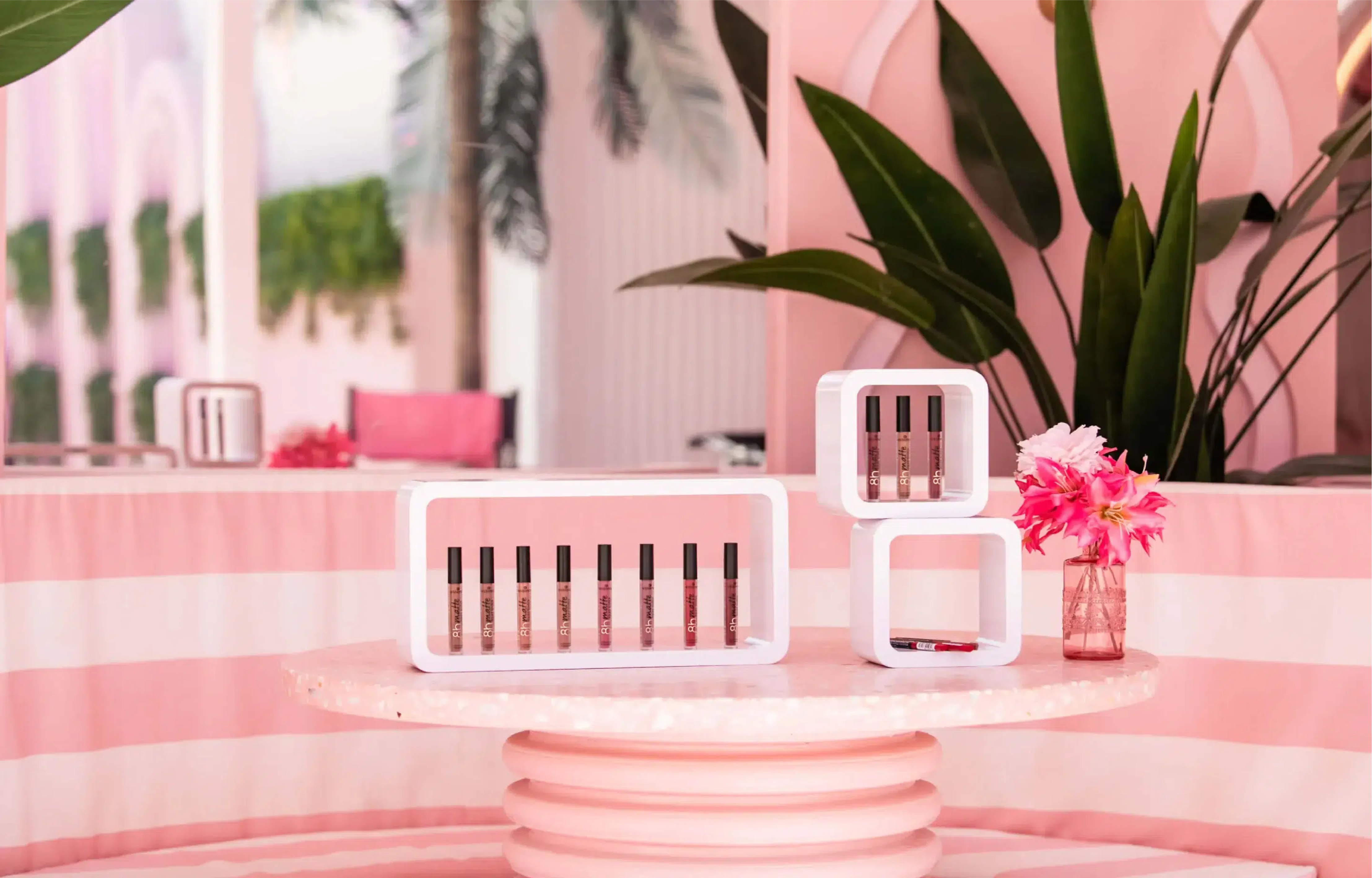 Pink table setup with displayed beauty products and plants