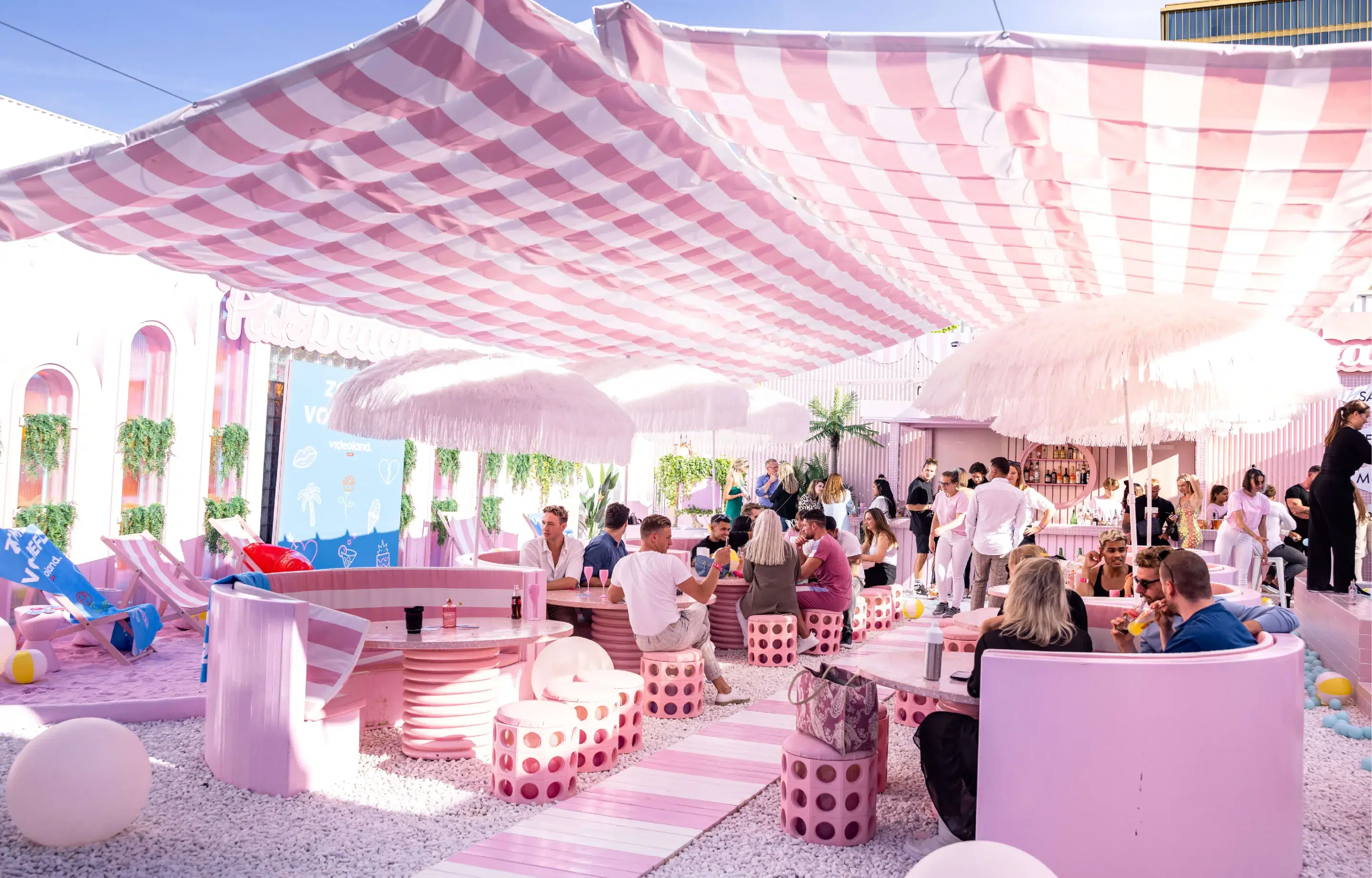 Guests relaxing in a pink outdoor lounge